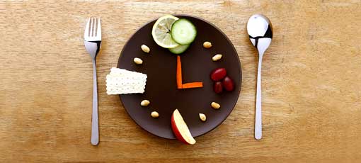 Obst und Gemüse Stücken als Uhr angeordnet auf Teller