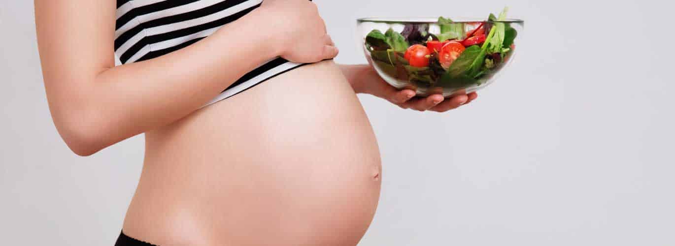 Gesunde Ernährung in der Schwangerschaft Gesunde Ernährung in der Schwangerschaft - Schwangere hält Salat in der Hand