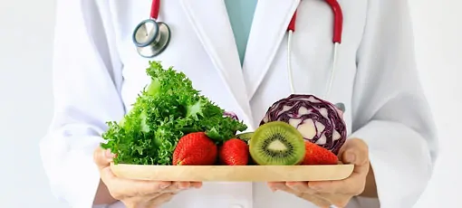 Arzt mit Gemüse und Obstteller