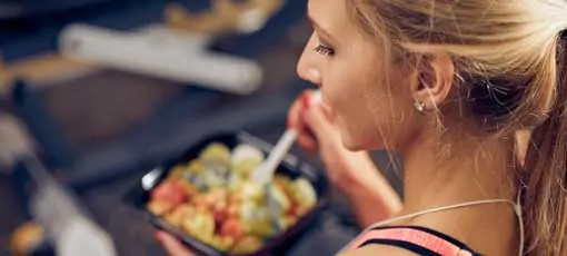 Top-Ansicht von Frauen, die gesundes Essen im Fitnessraum essen. Gesunder Lebensstil
