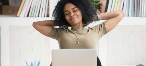 Ruhige afroamerikanische Geschäftsfrau mit Händen hinter Kopf entspannen in komfortablen Bürostuhl am Arbeitsplatz während der Pause, zufriedene weibliche Mitarbeiterin mit geschlossenen Augen träumen über gute Zukunft