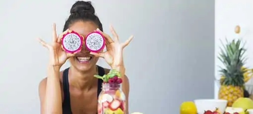 Ernährungsberater mit Fachrichtungen beim BTB - Frau hält sich Drachfrucht vor die Augen - wie eine Art Brille