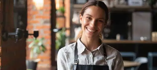 Head-Shot-Portrait erfolgreiche gemischte Geschäftsfrau glückliche Gaststätte oder Cafeteria-Besitzer, die Kamera anschauen, Frau mit Schürze lächelnd Gäste mit florierendem Catering-Business-Konzept